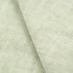 Miękki, jasnozielony len materiał z widoczną fakturą splotu.