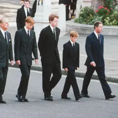 Książę Filip, książę William, książę Harry i książę Karol w czarnych garniturach i białych koszulach na pogrzebie. To przykład, jaka koszula na pogrzeb jest odpowiednia.