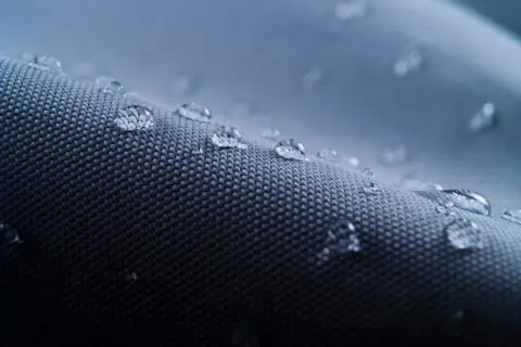 Krople wody na wodoodpornym materiale. To właśnie nylon, który chroni przed wilgocią.
