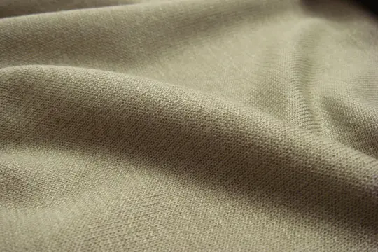 Miękki, beżowy dżersej, co to za materiał? Delikatna dzianina o widocznej strukturze, idealna na wygodne ubrania.
