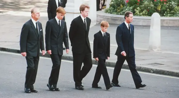 Książę Filip, książę William, książę Harry i książę Karol w czarnych garniturach i białych koszulach na pogrzebie. To przykład, jaka koszula na pogrzeb jest odpowiednia.
