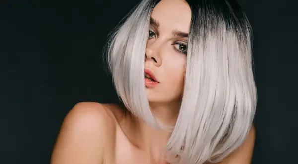 Kobieta z czarnymi włosami przechodzącymi w modny ombre blond.