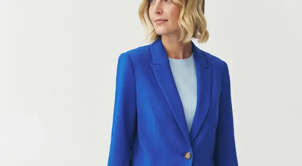 Kobieta w eleganckim, kobaltowym żakiecie, który pięknie podkreśla jej chabrowy styl.