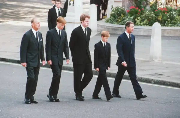 Książę Filip, książę William, książę Harry i książę Karol w czarnych garniturach i białych koszulach na pogrzebie. To przykład, jaka koszula na pogrzeb jest odpowiednia.