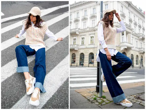 Elegancka stylizacja: jak nosić kamizelkę damską. Modelka w beżowej kamizelce, białej koszuli i jeansach na tle miasta.